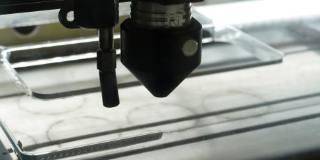 Laser nozzle mounted on an LS 100 while cutting acrylic