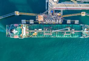 Top-down view of cargo ship being refueled and loaded
